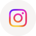 Auf einem beigen Kreis ist das Logo von Instagram, eine bunte Kamera, abgebildet.